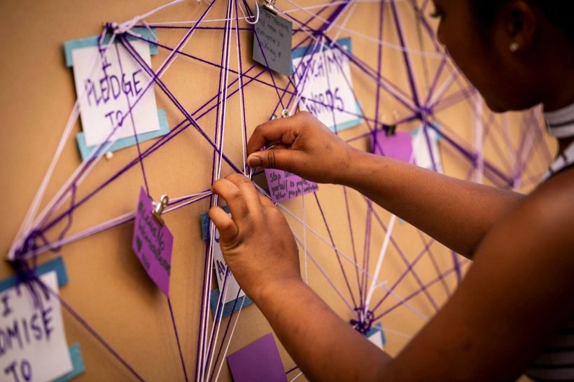 Hands building the interactive Pledge web